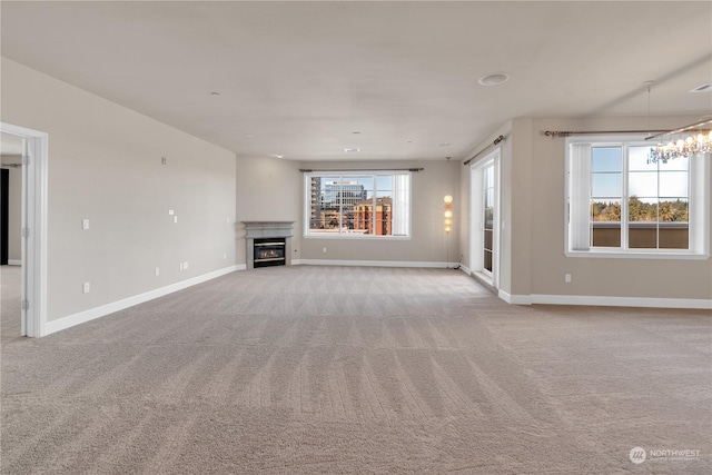 unfurnished living room featuring light colored carpet and a notable chandelier