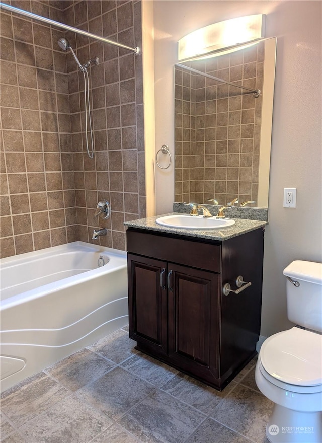 full bathroom with vanity, tiled shower / bath, and toilet