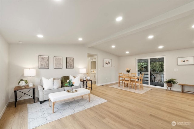 living room featuring light hardwood / wood-style floors and vaulted ceiling with beams