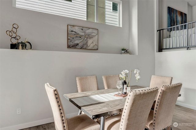 dining room with hardwood / wood-style flooring and a healthy amount of sunlight