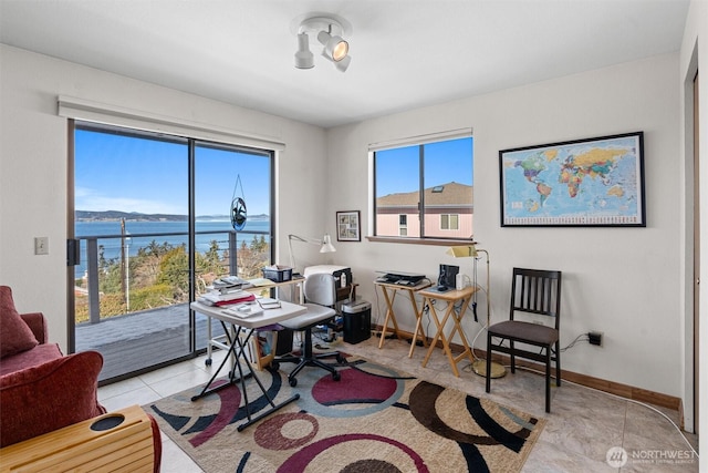 office area with a water view and light tile patterned floors