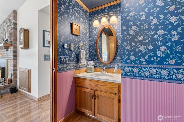 bathroom featuring hardwood / wood-style flooring, crown molding, and vanity