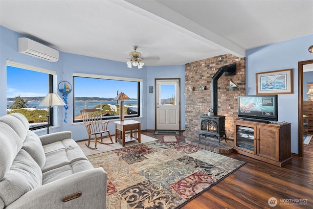 living room featuring an AC wall unit, a wood stove, ceiling fan, beamed ceiling, and dark hardwood / wood-style floors