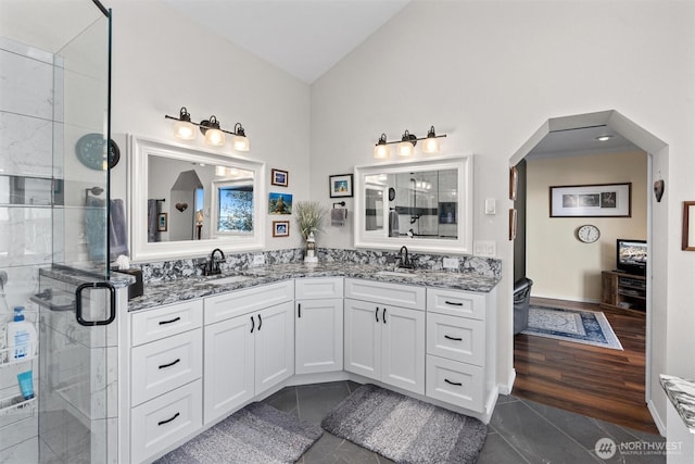 bathroom featuring vanity, an enclosed shower, tile patterned floors, and lofted ceiling