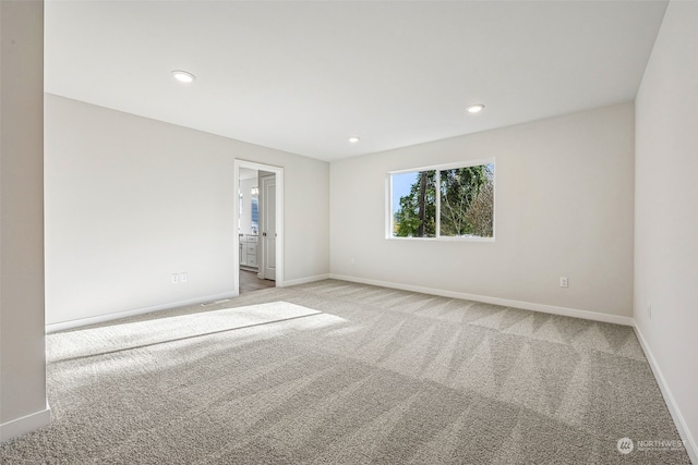 unfurnished room featuring light carpet