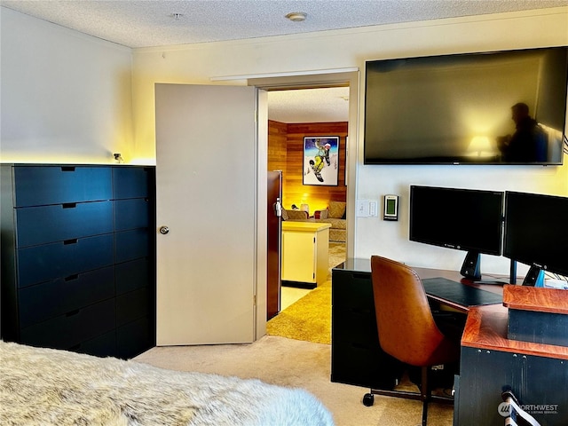 carpeted bedroom with refrigerator, a textured ceiling, and wood walls