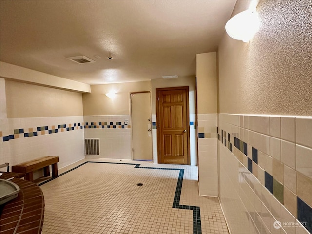 interior space featuring tile walls and light tile patterned floors