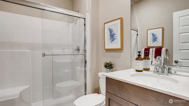 bathroom with vanity, toilet, and a shower with shower door