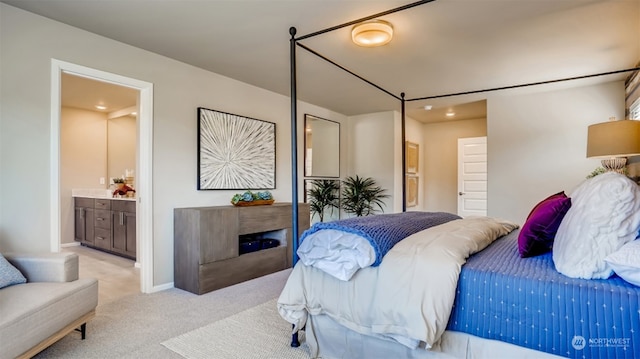 bedroom featuring ensuite bath and light colored carpet