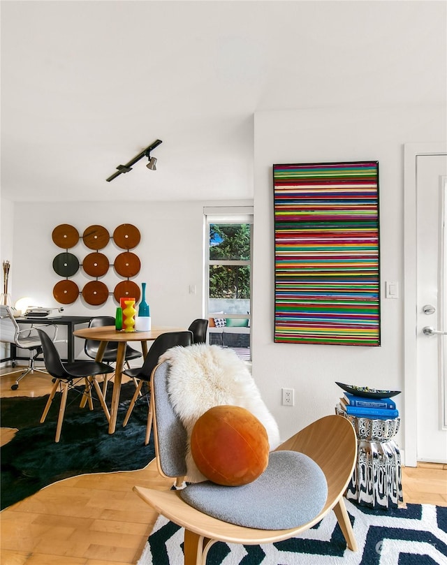 dining space featuring rail lighting and hardwood / wood-style floors