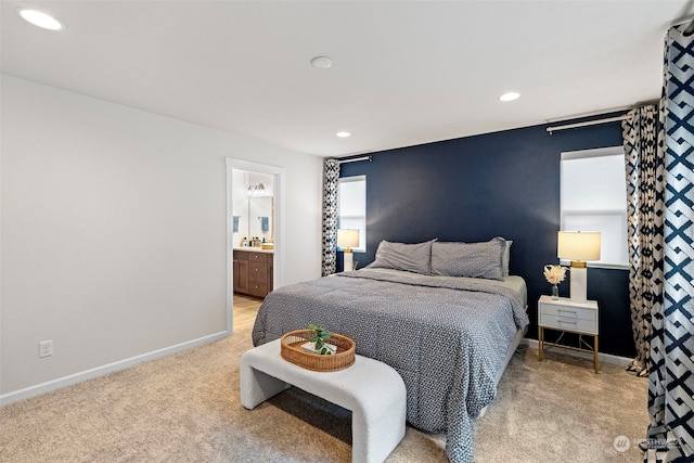 bedroom featuring light carpet and ensuite bath