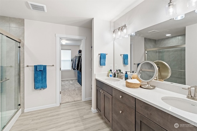 bathroom featuring vanity, a shower with door, and hardwood / wood-style floors