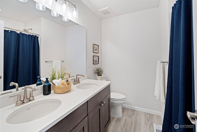 bathroom with hardwood / wood-style flooring, vanity, and toilet