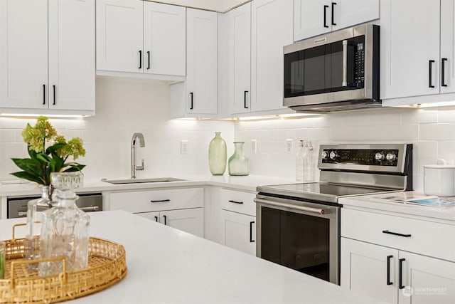 kitchen featuring white cabinetry, sink, decorative backsplash, and appliances with stainless steel finishes