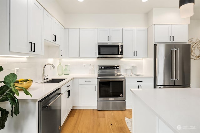 kitchen with white cabinetry, sink, tasteful backsplash, and stainless steel appliances