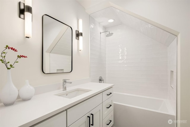 bathroom featuring tiled shower / bath combo and vanity