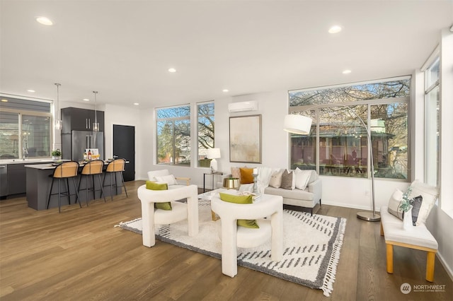 living room featuring hardwood / wood-style floors and an AC wall unit