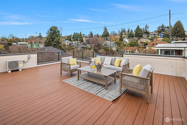 wooden terrace with outdoor lounge area and a wall mounted AC