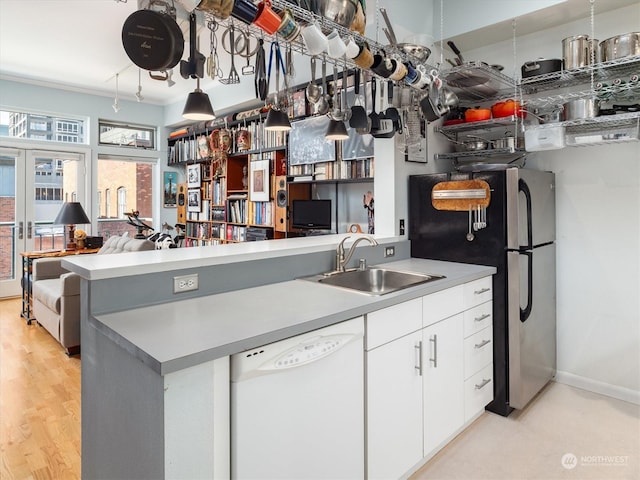 kitchen with french doors, sink, white cabinetry, stainless steel refrigerator, and dishwasher