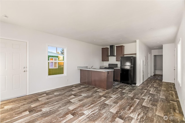 kitchen with wall chimney range hood, sink, black appliances, dark hardwood / wood-style flooring, and kitchen peninsula