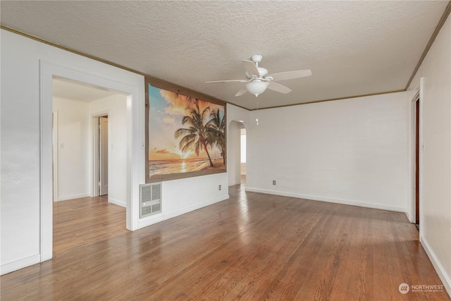 empty room featuring hardwood / wood-style floors, ornamental molding, a textured ceiling, and ceiling fan