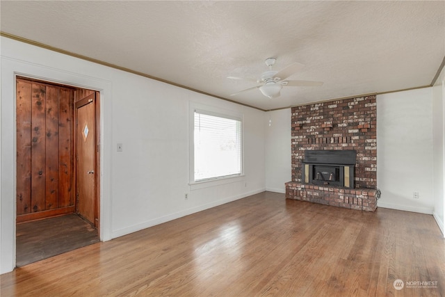 unfurnished living room with crown molding, ceiling fan, a textured ceiling, and light hardwood / wood-style flooring