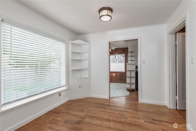 empty room featuring wood-type flooring and crown molding