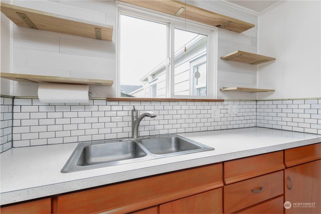 kitchen with crown molding, sink, a wealth of natural light, and backsplash