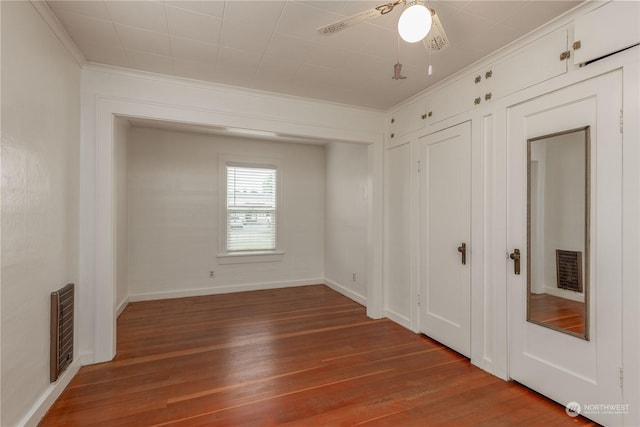 unfurnished bedroom featuring ornamental molding, hardwood / wood-style floors, and ceiling fan