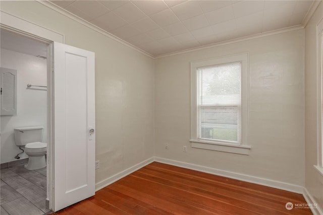 empty room featuring crown molding and wood-type flooring