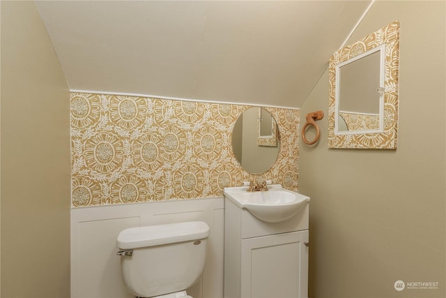 bathroom with vanity, vaulted ceiling, and toilet