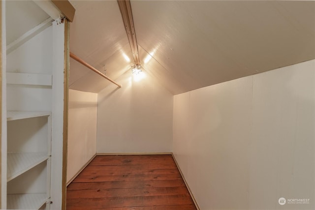 walk in closet with lofted ceiling and dark hardwood / wood-style flooring