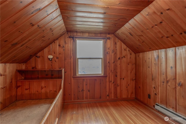 additional living space with vaulted ceiling, wooden walls, baseboard heating, wooden ceiling, and light wood-type flooring