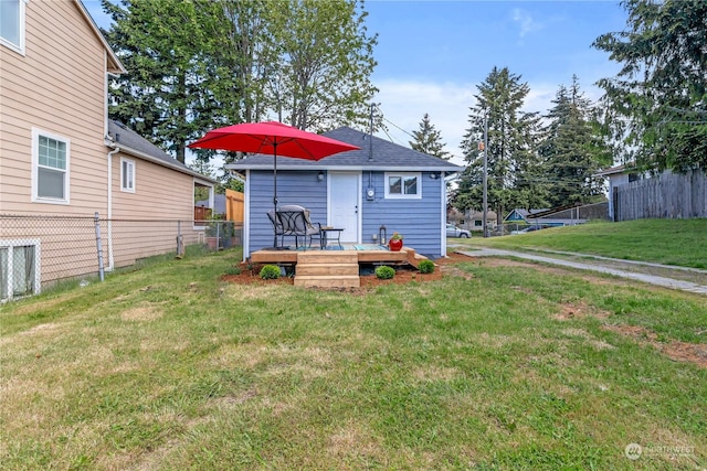 rear view of property with a deck and a lawn