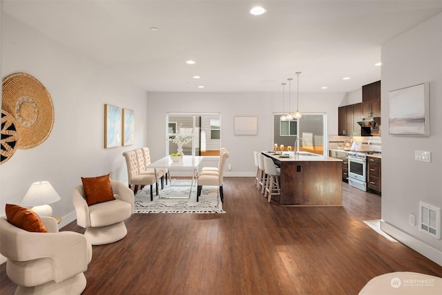 living room with sink, an inviting chandelier, and dark hardwood / wood-style flooring