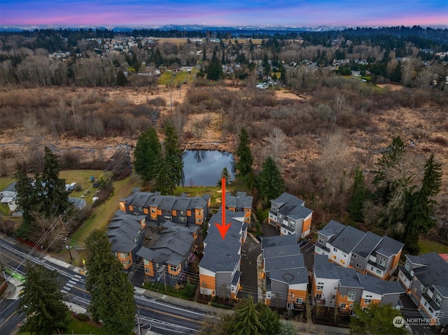 aerial view at dusk featuring a water view