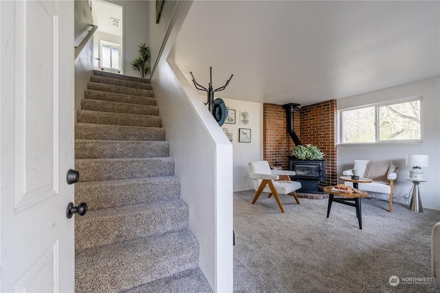 stairway with carpet flooring and a wood stove