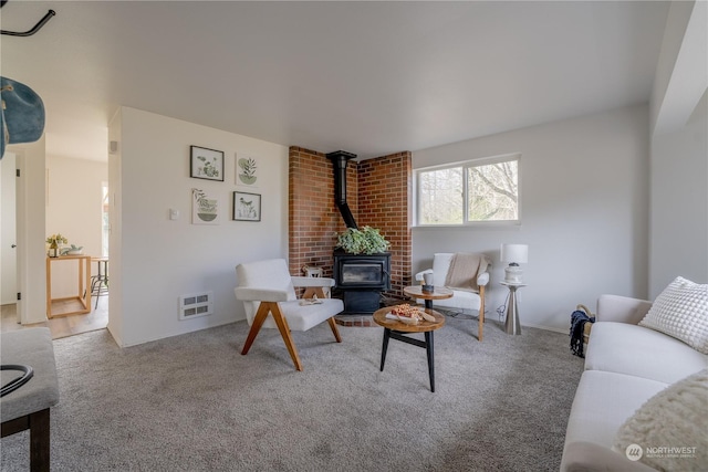 carpeted living room featuring a wood stove and heating unit