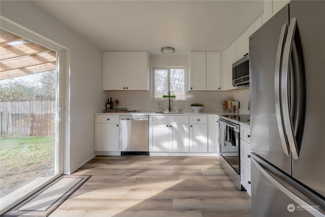 kitchen with white cabinetry, sink, a wealth of natural light, and stainless steel appliances