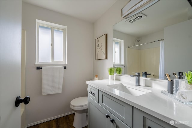 full bathroom with hardwood / wood-style flooring, vanity, shower / bathtub combination, and toilet