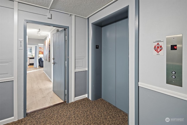 corridor with dark carpet and elevator