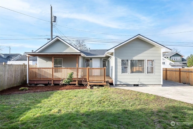 back of house featuring a wooden deck and a lawn