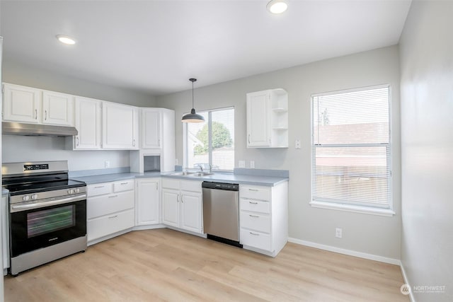 kitchen featuring pendant lighting, sink, white cabinets, light hardwood / wood-style floors, and stainless steel appliances