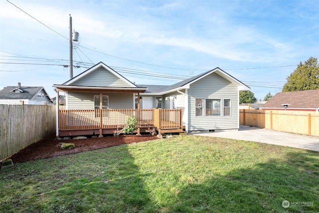 rear view of house featuring a patio area, a lawn, and a deck