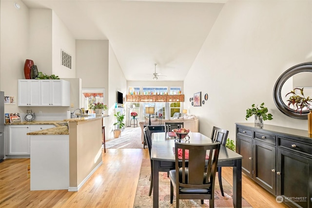 dining room featuring sink, light hardwood / wood-style flooring, and a healthy amount of sunlight