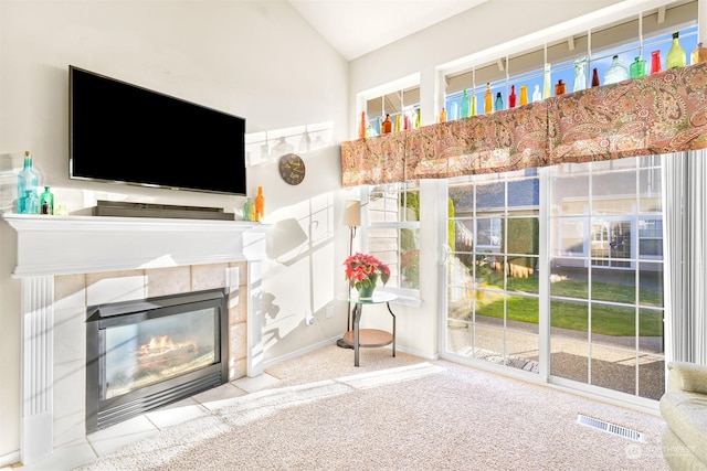 unfurnished living room with lofted ceiling and a tile fireplace