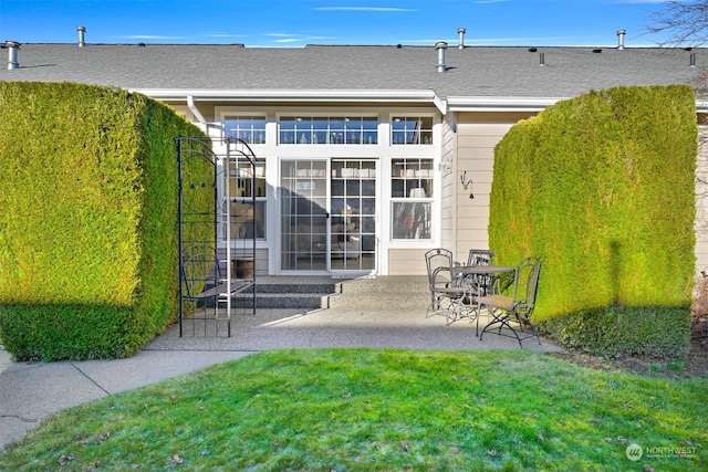 back of house with a patio area and a lawn