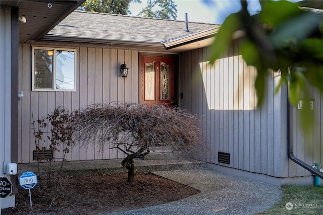 entrance to property with roof with shingles