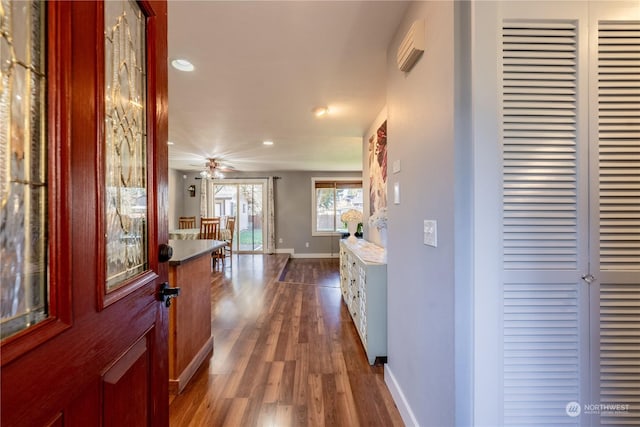 corridor with recessed lighting, dark wood finished floors, and baseboards