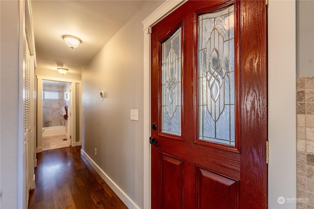 entryway with dark wood-type flooring and baseboards